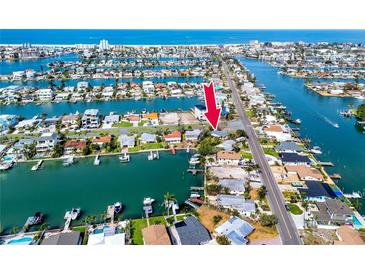 Aerial view of waterfront property with access to the Gulf, featuring a canal and nearby community at 11465 7Th E St, Treasure Island, FL 33706