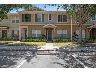 Townhouse exterior featuring neutral colors, manicured landscaping, and well-maintained facade at 12437 Foxmoor Peak Dr, Riverview, FL 33579