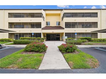 Condo building exterior with well-maintained landscaping, sidewalks, and covered parking at 13612 S Village Dr # 5201, Tampa, FL 33618