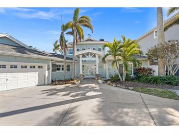 Beautiful two story home featuring a grand entrance, lush landscaping, and a spacious three car garage at 17077 Dolphin Dr, North Redington Beach, FL 33708
