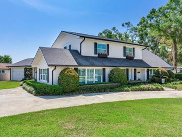 Charming two-story home with manicured landscaping, black shutters, and a long concrete driveway at 3724 Fawn Grove Ct, Land O Lakes, FL 34639