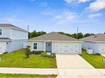 Charming single-story home featuring a well-maintained lawn, light gray paint, and a welcoming blue front door at 14532 Whitewater Way, Brooksville, FL 34604