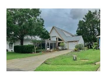 Charming single-Gathering home features a unique architectural design, lush landscaping, and a well-maintained front yard at 20989 Negril, Lutz, FL 33558