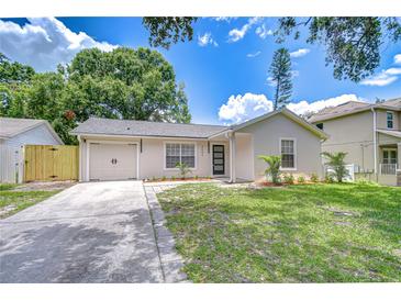 Charming single-story home features a well-manicured lawn, attached garage and inviting modern entrance at 4605 W Loughman St, Tampa, FL 33616