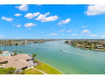 Stunning aerial view of the waterfront property featuring a serene pool and lush green landscaping at 9425 Blind Pass Rd # 1008, St Pete Beach, FL 33706