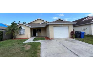 Charming single Gathering home with attached garage and well-manicured front lawn at 12804 Millridge Forest St, Tampa, FL 33624