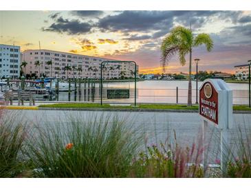 Beautiful waterfront community view with palm trees and dock at sunset, showcasing a peaceful location at 3018 59Th S St # 209, Gulfport, FL 33707