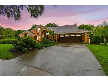 Charming home with well-manicured landscaping, a spacious driveway, and a two-car garage at 3308 Landing Pl, Palm Harbor, FL 34684