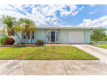 Charming single-story home featuring a well-maintained lawn, palm trees, and a clean, attached garage at 5377 Springwood Blvd, Pinellas Park, FL 33782