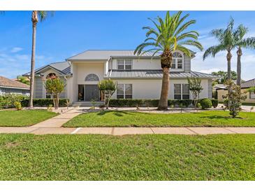 Stunning two-story home boasts lush landscaping, a manicured lawn, and a striking gray roof at 7114 Pelican Island Dr, Tampa, FL 33634