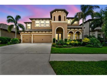 Stunning two-story home featuring a three-car garage and lush landscaping in a tropical setting at 11407 Drifting Leaf Dr, Riverview, FL 33579