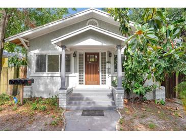 Charming home featuring a wood front door with glass panes and gray brick pillars at the entrance at 2808 N Highland Ave, Tampa, FL 33602