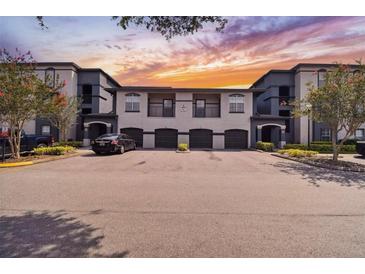 Condominium building with garages and black car parked in front during daytime with nicely landscaped yard at 8517 Island Breeze Ln # 207, Temple Terrace, FL 33637