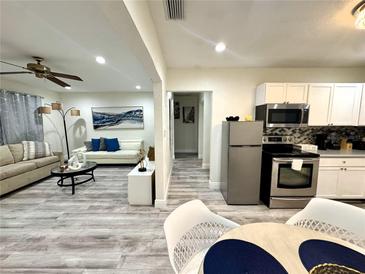 Open-concept living area features a modern kitchen, comfortable seating, and stylish decor at 1515 E Hanna Ave, Tampa, FL 33610