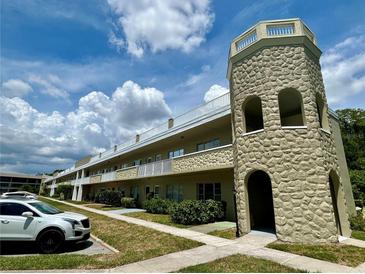 Multi-level building showcasing the architecture with stone tower and white balcony railings at 2391 Sumatran Way # 37, Clearwater, FL 33763