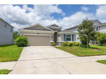 Charming single-story home featuring a well-maintained lawn, two-car garage, and lovely landscaping at 2898 Living Coral Dr, Odessa, FL 33556