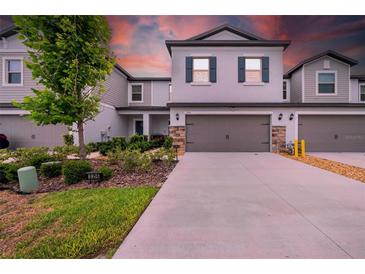 Charming two-story home features a two-car garage, manicured lawn and lush landscaping at 3216 Bryant Park Dr, New Port Richey, FL 34655