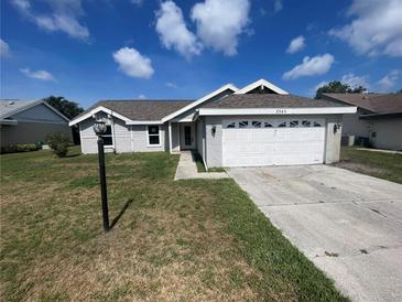 Single-story home featuring a two-car garage, neutral paint, and well-maintained landscaping under a bright, partly cloudy sky at 3541 65Th Avenue E Cir, Sarasota, FL 34243