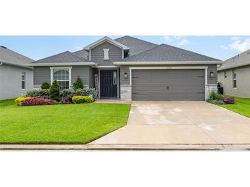 Charming single-story home featuring a well-manicured lawn and a two-car garage at 6226 165Th E Dr, Parrish, FL 34219