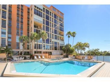 Resort-style pool and deck with lounge seating and palm trees at the base of the building at 7400 Sun Island S Dr # 412, South Pasadena, FL 33707