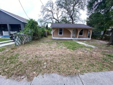 Charming single-story home featuring a cozy front porch and a yard with mature trees, offering great curb appeal at 8718 N Brooks St, Tampa, FL 33604