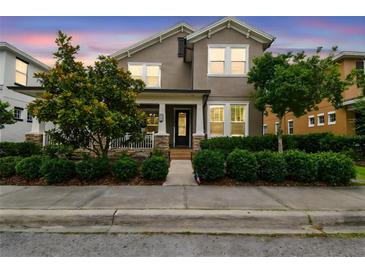 Charming two-story home featuring a covered porch, landscaped yard, and well-manicured shrubbery at 10422 Fenceline Rd, New Port Richey, FL 34655