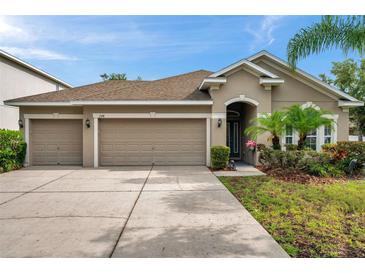 Charming single-story home with a three-car garage and well-manicured landscaping at 1328 Rushgrove Cir, Dover, FL 33527