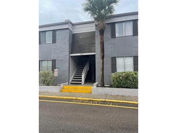 Two-story condominium building in gray with dark shutters and a palm tree at 3802 Cortez Cir # D, Tampa, FL 33614