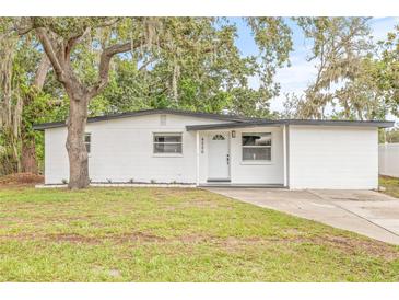Charming renovated single-story home featuring a modern white exterior and well-maintained front lawn at 4220 E Regnas Ave, Tampa, FL 33617