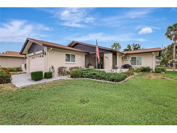 Inviting single-story home featuring a well-manicured lawn, mature landscaping, and charming front porch at 4512 Superior Ln, Clearwater, FL 33762