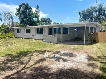 Charming single-story home with a well-maintained lawn and covered parking at 4722 Harris Ave, Sarasota, FL 34233