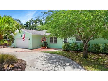 Charming home showcasing a lush front yard, with a long drive-way and an attached one-car garage at 6011 Tangerine S Ave, Gulfport, FL 33707