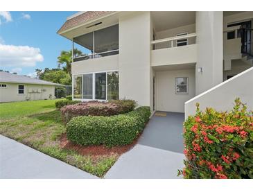 Inviting condo featuring mature landscaping, a screened porch, and a private entrance at 7304 W Country Club N Dr # 113, Sarasota, FL 34243