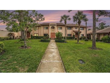 Charming two-story townhome showcasing landscaped front yard, manicured hedges, and a tile roof at 9521 86Th Ave # 9521, Seminole, FL 33777
