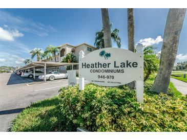 Heather Lake Condominiums is showcased with lush landscaping and convenient covered parking in this exterior daytime image at 960 Virginia St # 202, Dunedin, FL 34698