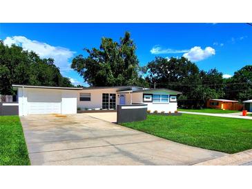 Charming one-story home featuring modern paint, green grass, and a spacious driveway at 1373 Fairfax Rd, Clearwater, FL 33764