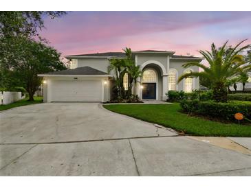 Charming two-story home with a well-manicured lawn, arched entry, and a two-car garage at 16003 Ridley Pl, Tampa, FL 33647