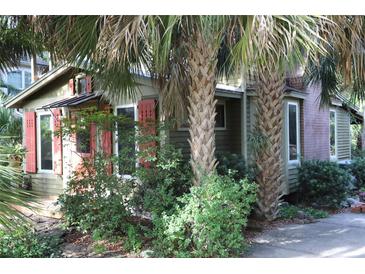 Charming home with red shutters and lush tropical landscaping creates a private retreat at 272 Orange St, Palm Harbor, FL 34683