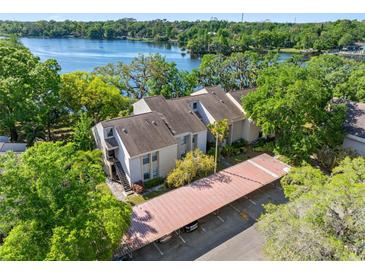 An exterior view of the condos, with a view of the lake and covered parking at 5122 Puritan Cir # 5122, Tampa, FL 33617