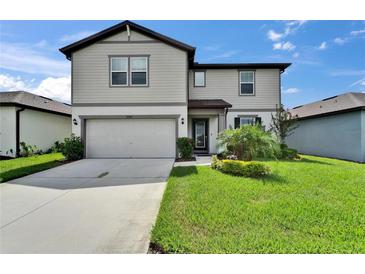 Charming two-story home with a well-manicured lawn, lush landscaping and attached two-car garage at 6658 Devlin Ln, Wesley Chapel, FL 33545