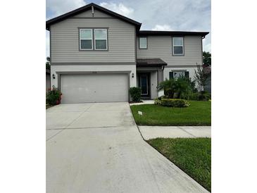 Charming two-story home with a well-manicured lawn and attached two car garage at 6658 Devlin Ln, Wesley Chapel, FL 33545