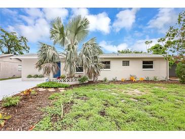 Charming single-story home with a blue door, desert landscaping, and a bright sky above at 821 52Nd S Ave, St Petersburg, FL 33705