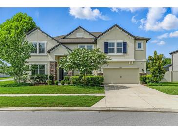 Charming two-story home featuring a manicured lawn, beautiful landscaping, and a two-car garage at 18696 Malinche Loop, Spring Hill, FL 34610