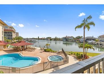 A luxurious pool and spa area overlooks a scenic waterfront with boat docks at 105 Island Way # 126, Clearwater Beach, FL 33767