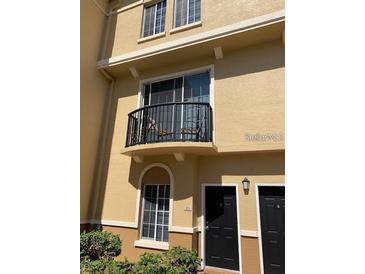 Two-story condo featuring a balcony with seating and black doors at 125 Grand Beach Pl # 125, Tampa, FL 33609