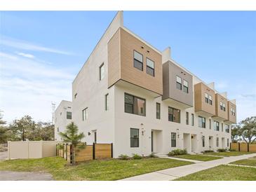 Modern three-story townhome showcases a contemporary design with neutral colors and manicured landscaping at 321 15Th N St, St Petersburg, FL 33705