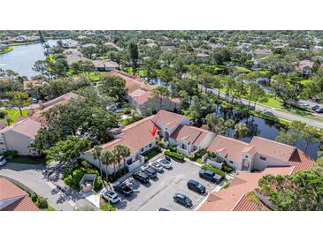 An aerial view of a cozy, gated community with lush landscaping, ponds, and ample parking at 4783 Palermo Ne Ct # 4783, St Petersburg, FL 33703