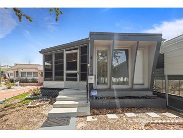 Cozy single-story home with a screened-in porch and modern gray and white exterior at 4851 W Gandy Blvd # B1L8, Tampa, FL 33611