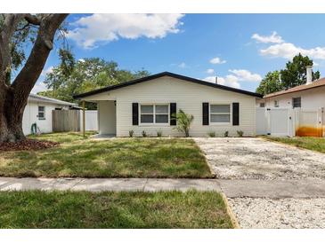 Charming single-story home featuring a well-manicured lawn and gravel driveway at 621 89Th N Ave, St Petersburg, FL 33702