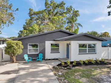 Charming single-story home with a brick accent wall, blue front door and well-manicured landscaping at 6738 Criswell N Ave, St Petersburg, FL 33709